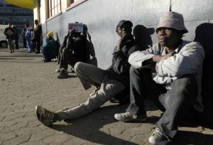 Unemployed Men Wait On A Street Corner For Part Time Work In